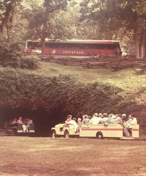 A Jefferson Lines bus from the 1970s parked above vacationers