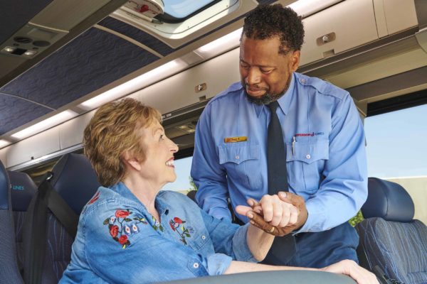 Jefferson Lines bus driver greeting woman passenger in her seat